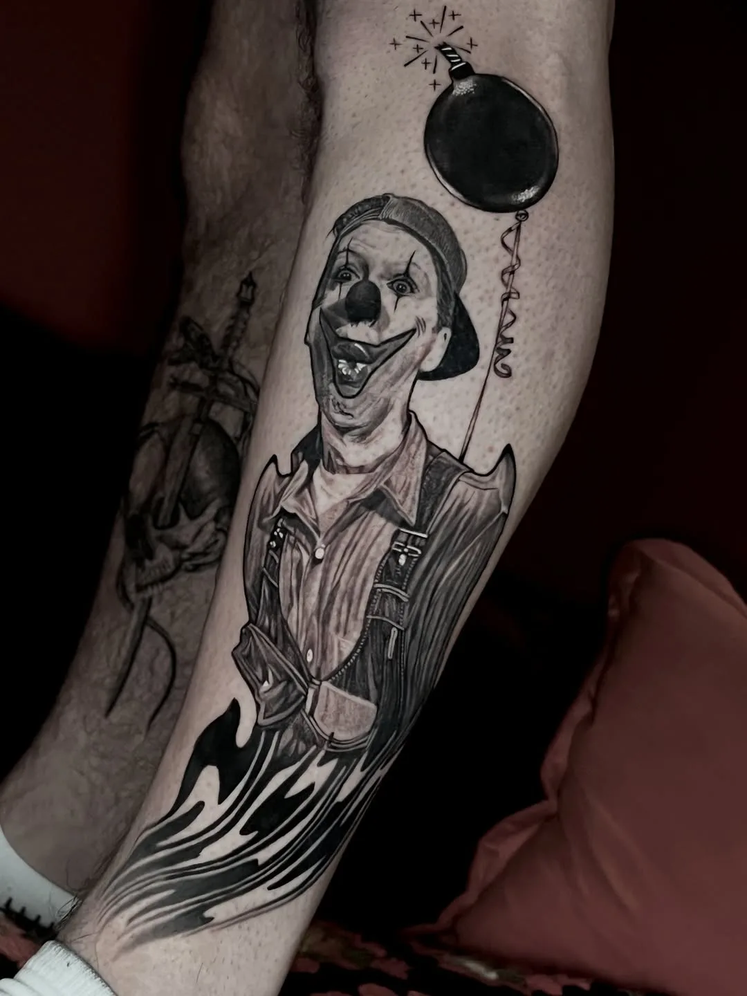 Clown holding a bomb balloon, black and grey leg tattoo