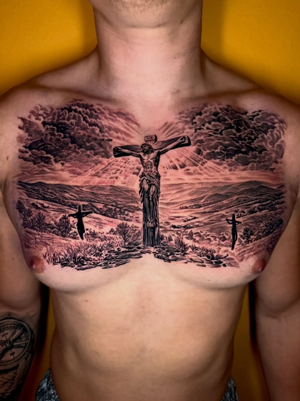 Large black and grey crucifixion scene chest tattoo