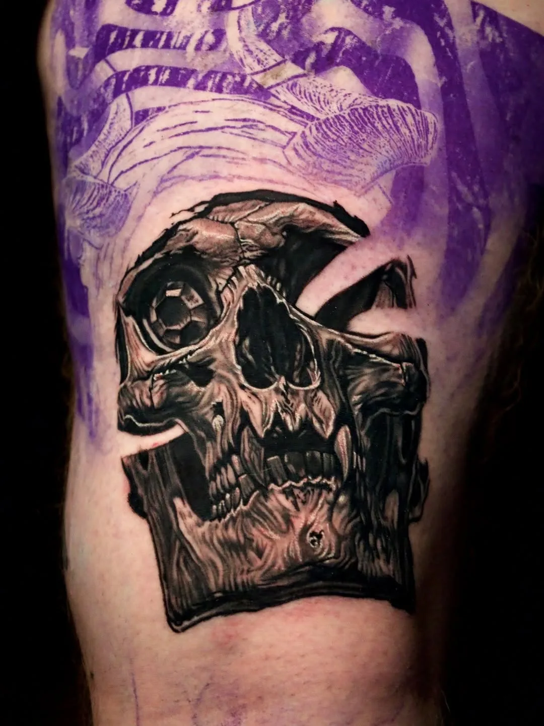 Demon skull tattoo with fresh stencil work, black and grey upper arm
