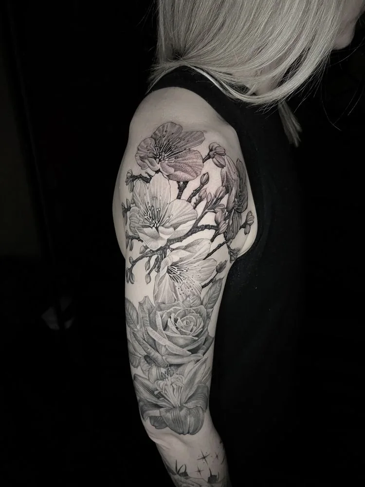Black and grey floral woman portrait upper-arm tattoo