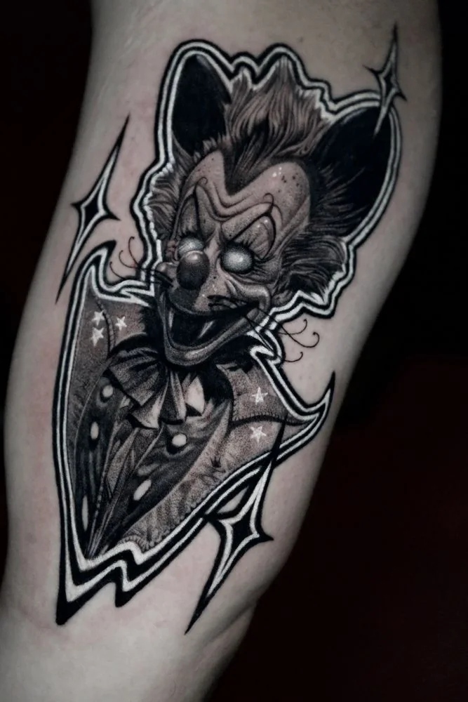 Black and grey Joker clown tattoo with geometric framing