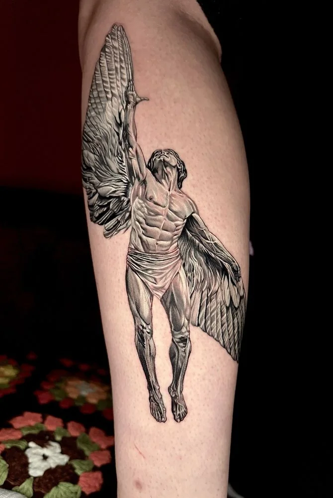 Fine-line black and grey winged figure tattoo